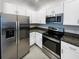 Modern kitchen with white cabinets, granite countertops and stainless steel appliances at 6856 Ripple Pond Loop, Zephyrhills, FL 33541
