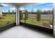 View of the screened porch and backyard with lush green grass and landscaping at 6856 Ripple Pond Loop, Zephyrhills, FL 33541
