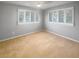 Bright bedroom featuring plantation shutters on two windows, carpeted floor, and neutral walls at 9665 Tara Cay Ct # 41, Seminole, FL 33776