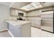Well-lit kitchen with granite counters, stainless steel appliances, tile flooring, and light gray cabinetry at 6262 142Nd N Ave # 1203, Clearwater, FL 33760