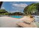 Community pool with lounge chairs and a large deck surrounded by mature trees at 6262 142Nd N Ave # 1203, Clearwater, FL 33760