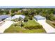 Expansive property featuring a lush green lawn, mature trees, and a matching detached two-car garage at 3215 Peace River Dr, Punta Gorda, FL 33983