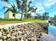Lush backyard showing the landscaping, riprap, and the house in the distance at 3215 Peace River Dr, Punta Gorda, FL 33983