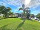 Spacious lawn with tropical landscaping, screened-in lanai, and waterfront dock and lift at 3215 Peace River Dr, Punta Gorda, FL 33983