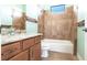 Well-lit bathroom featuring a tiled shower, bathtub, and vanity with granite countertop at 3215 Peace River Dr, Punta Gorda, FL 33983