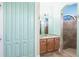 A bathroom has a sink with light wooden cabinets and a walk-in shower with a small window at 3215 Peace River Dr, Punta Gorda, FL 33983