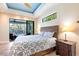 Bright bedroom features a decorative ceiling and accents, and a slider leading to a screened pool area at 3215 Peace River Dr, Punta Gorda, FL 33983