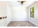 Neutral bedroom with a ceiling fan, tile flooring, and a window with a view of greenery at 3215 Peace River Dr, Punta Gorda, FL 33983