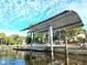 View of boat lift on the water with cover and bright blue skies in this waterfront neighborhood at 3215 Peace River Dr, Punta Gorda, FL 33983