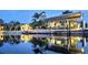 Scenic waterfront view of a boat lift and adjacent home at dusk with beautiful light reflections at 3215 Peace River Dr, Punta Gorda, FL 33983