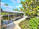 Canal-front dock featuring a boat lift, brick-paved walkway, and lush tropical landscaping at 3215 Peace River Dr, Punta Gorda, FL 33983