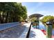 Scenic waterfront property featuring a boat dock with a covered boat lift and beautiful landscaping at 3215 Peace River Dr, Punta Gorda, FL 33983
