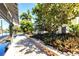 Waterfront dock with lush tropical landscaping featuring a paver walkway and covered boat lift at 3215 Peace River Dr, Punta Gorda, FL 33983