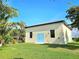 Exterior view of building with manicured lawn and serene tropical backdrop at 3215 Peace River Dr, Punta Gorda, FL 33983