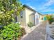 Charming exterior with lush landscaping, a shed, and a brick pathway leading to a vibrant turquoise door at 3215 Peace River Dr, Punta Gorda, FL 33983