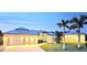 Stunning home with a metal roof, three-car garage, well-manicured lawn, and beautiful landscaping with palm trees at 3215 Peace River Dr, Punta Gorda, FL 33983
