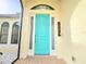 Welcoming front entrance with a teal door, decorative windows, and a bell at 3215 Peace River Dr, Punta Gorda, FL 33983