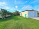 Side view of garage and yard featuring lush, green lawn and landscaping at 3215 Peace River Dr, Punta Gorda, FL 33983