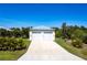 Detached two-car garage with a long driveway, surrounded by manicured landscaping at 3215 Peace River Dr, Punta Gorda, FL 33983