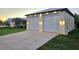 Detached two-car garage with a paved driveway, exterior lighting and meticulously manicured landscaping at 3215 Peace River Dr, Punta Gorda, FL 33983