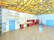 Bright garage featuring epoxy floor, red tool cabinets, an open rafter ceiling, and a vibrant blue door and trim at 3215 Peace River Dr, Punta Gorda, FL 33983