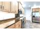 A kitchen features light wood cabinets, stainless steel appliances, and granite countertops for a modern, functional design at 3215 Peace River Dr, Punta Gorda, FL 33983
