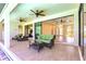 Covered outdoor lanai with wicker furnishings and ceiling fans, leading to bright interior at 3215 Peace River Dr, Punta Gorda, FL 33983