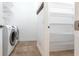 Modern laundry room featuring a washer and dryer with access to a walk-in closet at 3215 Peace River Dr, Punta Gorda, FL 33983