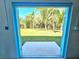 Expansive lush green views framed by a turquoise doorway create a captivating scene at 3215 Peace River Dr, Punta Gorda, FL 33983
