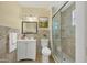 Well-lit bathroom with a glass-enclosed shower, vanity, and decorative mirror at 3803 Pin Oaks St, Sarasota, FL 34232