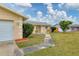 Exterior view showcasing the home's well-kept lawn, front entrance, and attached garage at 3803 Pin Oaks St, Sarasota, FL 34232