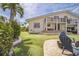 Expansive backyard featuring lush lawn, putting green, brick patio, covered porch, and second story balcony at 5900 Leeland S St, St Petersburg, FL 33715