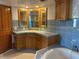 Stylish bathroom with blue tile, corner mirrors, and a soaking tub for relaxation at 5900 Leeland S St, St Petersburg, FL 33715