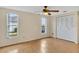Bedroom with laminate floors, fan, and large closet doors at 909 Kirkcaldy Way, Valrico, FL 33594