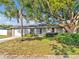 Inviting single-story home with a lush front yard, featuring mature trees and charming curb appeal at 909 Kirkcaldy Way, Valrico, FL 33594