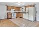 The open kitchen features tile floors, white appliances, and ample cabinet storage at 909 Kirkcaldy Way, Valrico, FL 33594