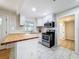 Well-lit kitchen with stainless steel appliances, butcher block counters, white cabinets, and white subway tile at 1121 49Th Ave N, St Petersburg, FL 33703