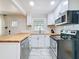 Updated kitchen boasts stainless steel appliances, butcher block countertops, subway tile backsplash, and bright lighting at 1121 49Th Ave N, St Petersburg, FL 33703