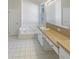 Bright bathroom featuring a soaking tub, large vanity and white tile floors at 11823 Derbyshire Dr, Tampa, FL 33626