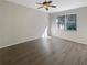 Bright bedroom featuring hardwood floors, a ceiling fan and a large window at 11823 Derbyshire Dr, Tampa, FL 33626