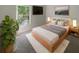 Bright bedroom features a modern platform bed, soft rug, and a large window with natural light and views at 11823 Derbyshire Dr, Tampa, FL 33626