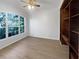 Bright bedroom featuring hardwood floors, a ceiling fan and large window providing plenty of natural light at 11823 Derbyshire Dr, Tampa, FL 33626