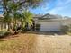 Charming single-story home with a two-car garage and mature landscaping, including palm trees at 11823 Derbyshire Dr, Tampa, FL 33626