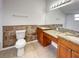 Bathroom features tile accents, double vanity with granite countertops, and a large mirror at 9509 Citrus Glen Pl # 11, Tampa, FL 33618