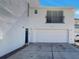 Modern two-story home featuring a two-car garage and balcony; freshly painted white with a blue front door at 9509 Citrus Glen Pl # 11, Tampa, FL 33618