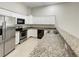 Bright kitchen featuring white cabinets, granite countertops, stainless steel appliances, and tile floors at 9509 Citrus Glen Pl # 11, Tampa, FL 33618