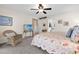 Cozy bedroom with floral bedding, ceiling fan, and decorative chair, perfect for relaxing and unwinding at 3699 N Chamberlain Blvd, North Port, FL 34286