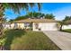 Charming single-story home with a well-maintained lawn, landscaped garden, and a two-car garage at 3699 N Chamberlain Blvd, North Port, FL 34286