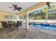 Outdoor living space featuring a screened-in pool with a spa, dining area, and patio at 3699 N Chamberlain Blvd, North Port, FL 34286