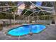 Outdoor oasis featuring a screened-in pool with spa and landscape at 3699 N Chamberlain Blvd, North Port, FL 34286
